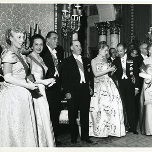 Visita do Presidente da República Craveiro Lopes ao Brasil. O Presidente do Brasil, Juscelino Kubitschek de Oliveira, o terceiro a contar da esquerda, com  o Chefe do Estado de Portugal, a seguir, durante uma receção; as respetivas mulheres, Berta Craveiro Lopes e Sara Kubitschek, a primeira e a segunda da esquerda.