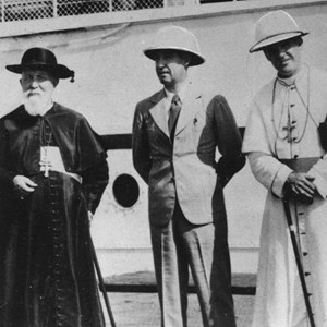 O major Francisco Craveiro Lopes, chefe da repartição do Gabinete do Governador-Geral da Índia, ao centro, acompanhado pelo patriarca das Índias Orientais e arcebispo de Goa e Damão, José da Costa Nunes, à esquerda, junto ao navio usado na travessia Goa-Bombaim.